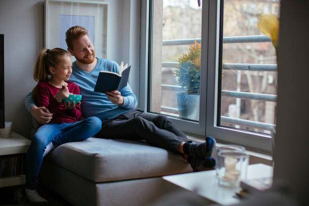 istock Father and daughter reading together 980011902