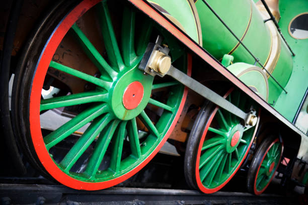 Nostalgic look at a bygone era. Close-up of the metal surfaces of a drive wheel and other complex mechanical components of a locomotive from the 1930s.