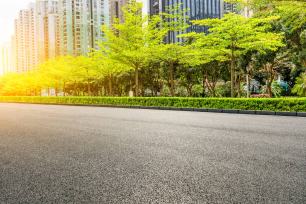 istock Asphalt road and modern commercial buildings with trees 980018710