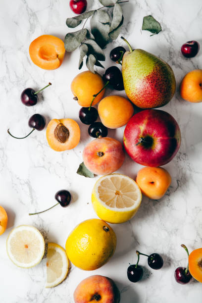 verano frutas surtidos sobre fondo de mármol blanco. concepto de alimentos crudos frescos. - fruit stone fotografías e imágenes de stock