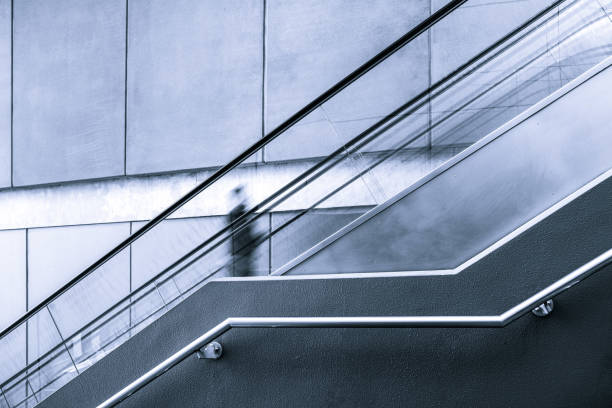 istock Blurred motion of one person on escalator with copy space 980034862