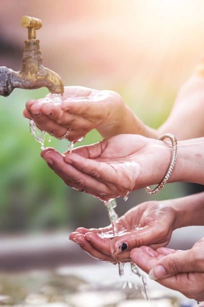 Cupped hand under tap water. social issue