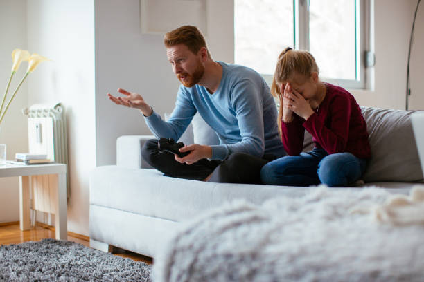 istock Father and daugther playing video games 980049484