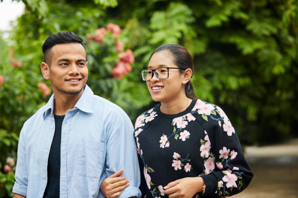 istock Loving young couple walking in park 980049602