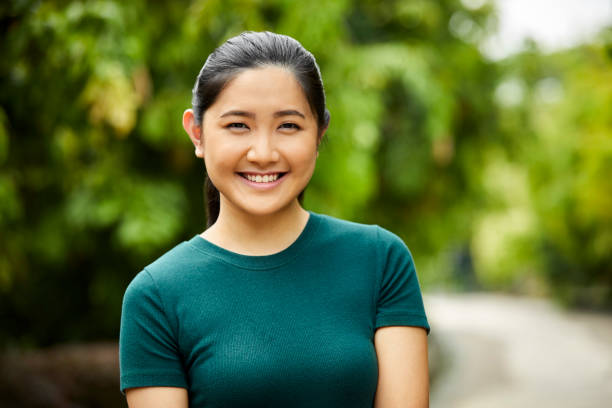 istock Close-up portrait of young woman smiling in park 980049708