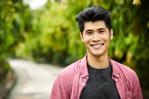 istock Portrait of confident young man smiling in park 980049728
