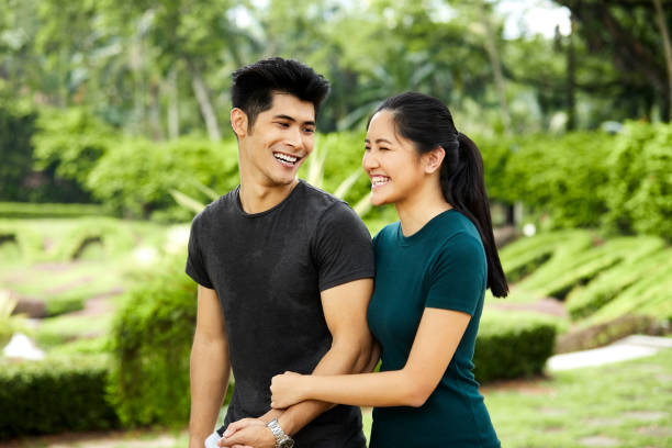 istock Smiling young couple walking in park 980049798