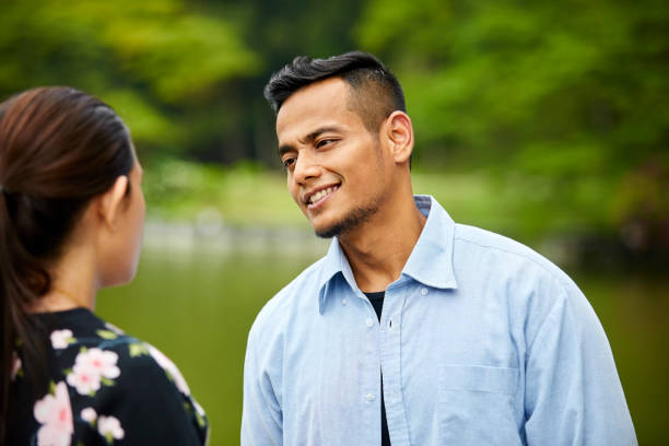 istock Loving young man looking at girlfriend in park 980050016