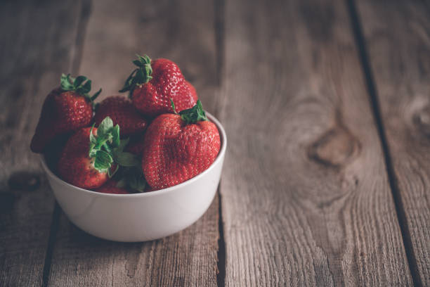 istock Plate of Strawberries at old wooden table 980050220