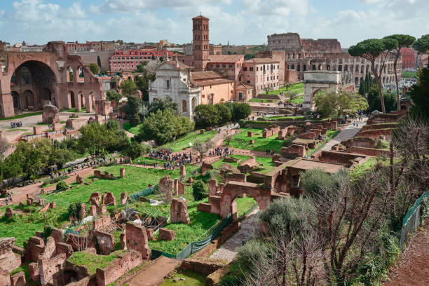 roma, las ruinas de los agujeros imperiales, el coliseo de fondo - imperial italy rome roman forum fotografías e imágenes de stock