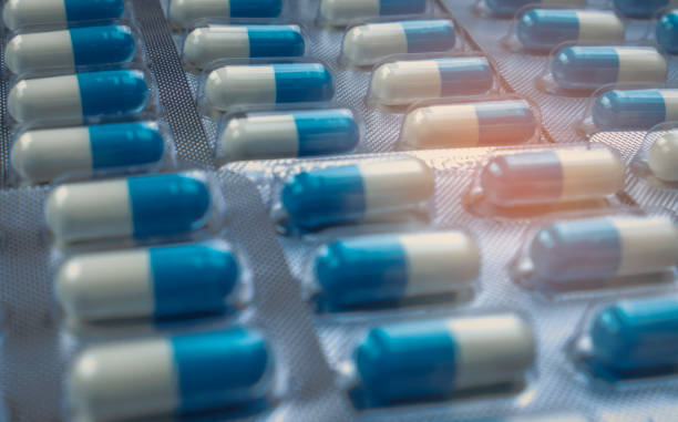 istock Blue and white capsules pill in blister pack arranged with beautiful pattern. Global healthcare concept. Antibiotics drug resistance. Antimicrobial capsule pills. Pharmaceutical industry. 980061976