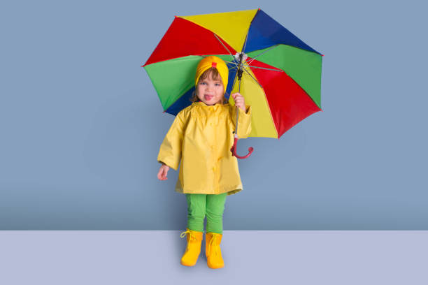 istock Happy funny child with color umbrella posing on wall background. 980066288