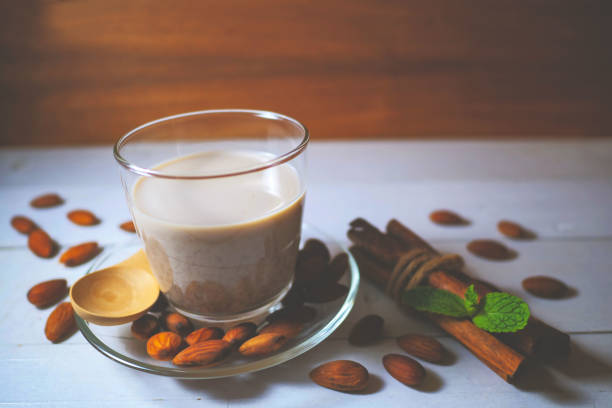 istock Almond milk in a glass with almonds. Cinnamon sticks  Decoration 980070492