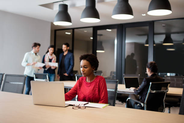 istock Beautiful young woman working in open space with laptop 980070508