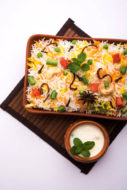 Indian Vegetable Pulav or Biryani made using Basmati Rice, served in a ceramic bowl. selective focus