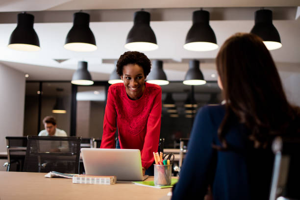 istock Two female coworkers sitting at table and working together 980074628