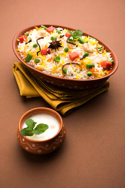 istock Indian Vegetable Pulav or Biryani made using Basmati Rice, served in a ceramic bowl. selective focus 980074740
