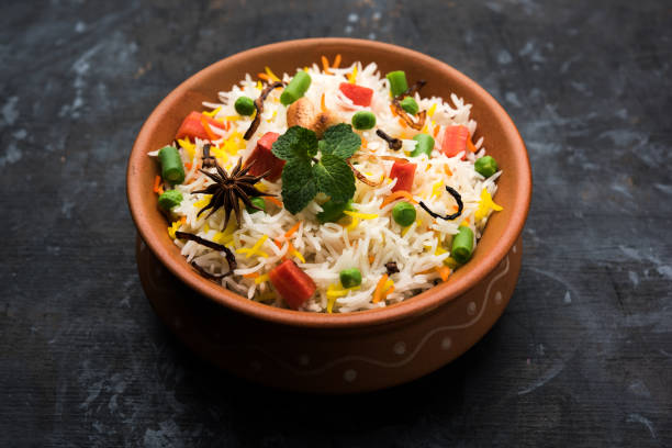 istock Indian Vegetable Pulav or Biryani made using Basmati Rice, served in a ceramic bowl. selective focus 980075026