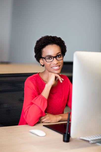 istock Beautiful young woman working in front of computer 980075062