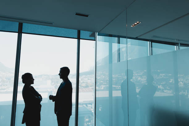 istock Silhouette of business people standing and talking 980075184