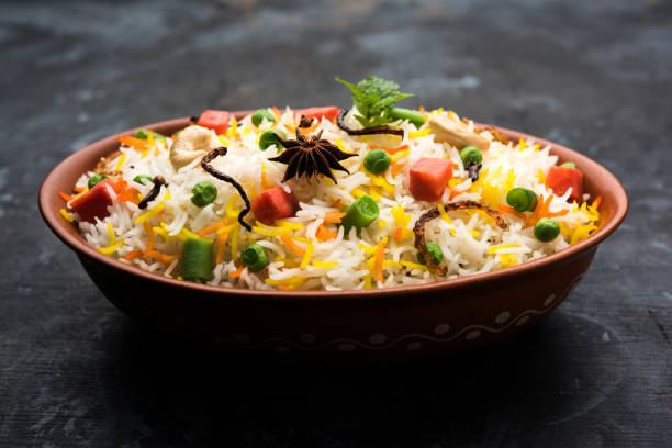istock Indian Vegetable Pulav or Biryani made using Basmati Rice, served in a ceramic bowl. selective focus 980075308