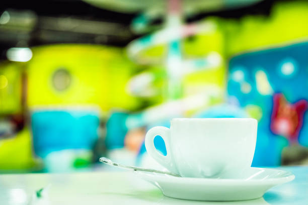 Blur image of playground in the mall with coffee cup, use for background.