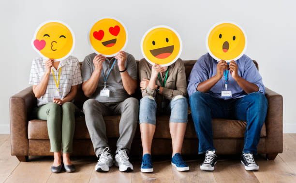 istock Diverse people sitting and covering face with emojis boards 980075796
