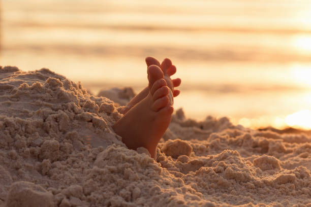 Closeup child kid feet on white sand beach. Sea on background, concept of a relaxing holiday on the coast