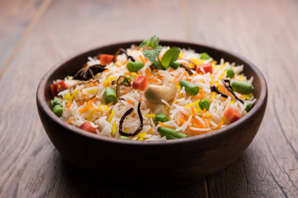 istock Indian Vegetable Pulav or Biryani made using Basmati Rice, served in a ceramic bowl. selective focus 980079194