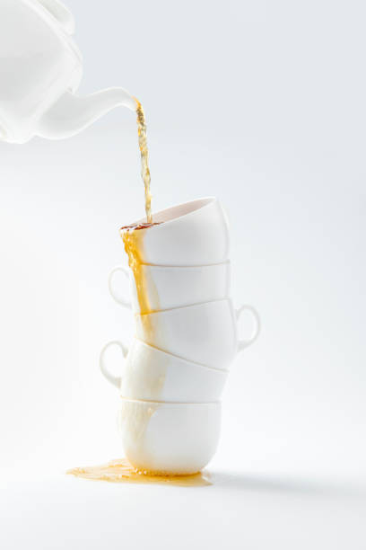 istock composition of pouring tea from teapot in cups isolated on white 980079224