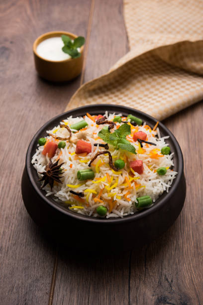 istock Indian Vegetable Pulav or Biryani made using Basmati Rice, served in a ceramic bowl. selective focus 980079312