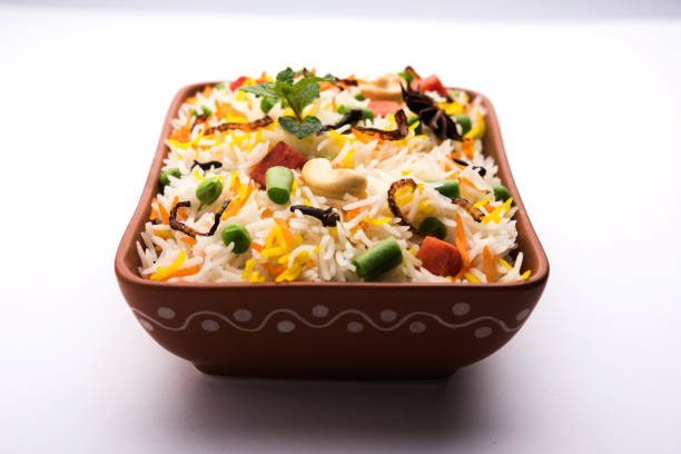 Indian Vegetable Pulav or Biryani made using Basmati Rice, served in a ceramic bowl. selective focus