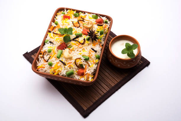 Indian Vegetable Pulav or Biryani made using Basmati Rice, served in a ceramic bowl. selective focus