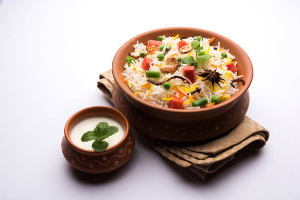 istock Indian Vegetable Pulav or Biryani made using Basmati Rice, served in a ceramic bowl. selective focus 980083592