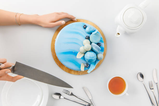 istock top view of cropped hands slicing cake on chopping board isolated on white 980084694