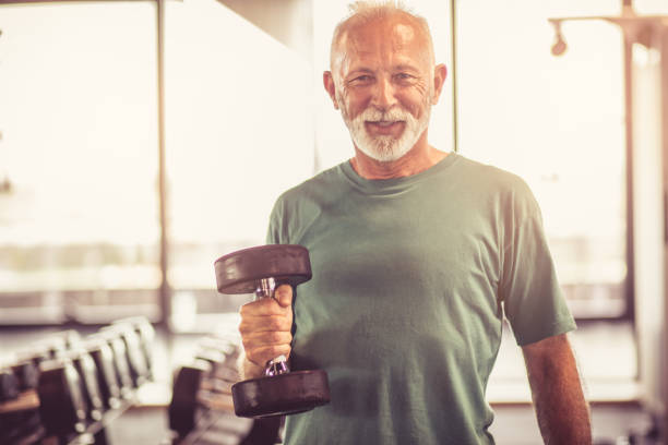 istock Smiling senior man with weight at gym 980088042