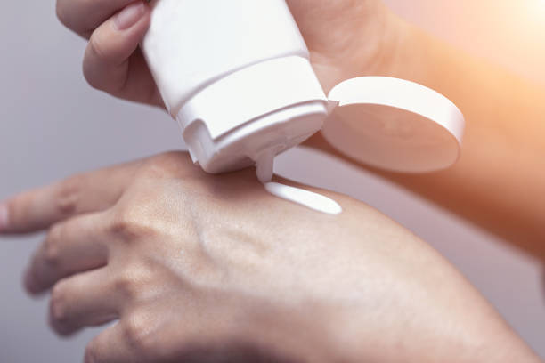 istock Young woman is using sun block lotion on her hand, beauty concept. 980091390