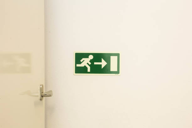 istock The emergency exit sign shows the direction of escape in case of danger. The emergency exit board hangs on the ceiling of the building. 980091480