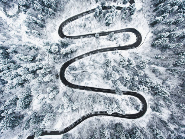 istock Winding road in the mountains in winter time 980094886