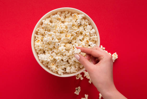 istock Bucket of popcorn on red background, top view 980096886