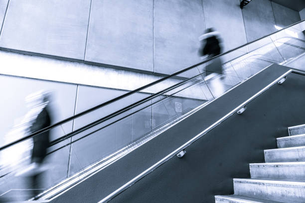 istock Blurred motion of people going down an escalator 980097106