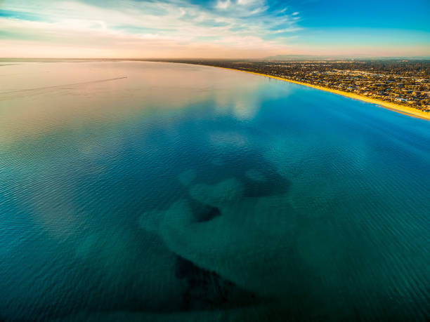 istock Smooth shallow ocean water surface with cloud reflections near coastline at sunset 980105864