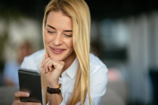 istock Beautiful blond woman using smartphone 980106614
