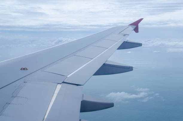 istock Airplane wing in the blue sky with white clouds 980114304
