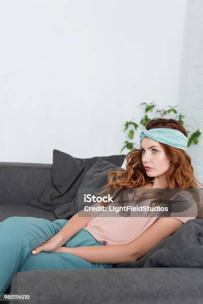 Thoughtful Stylish Woman Sitting On Couch At Home Stock Photo - Download Image Now - Adult, Adults Only, Apartment