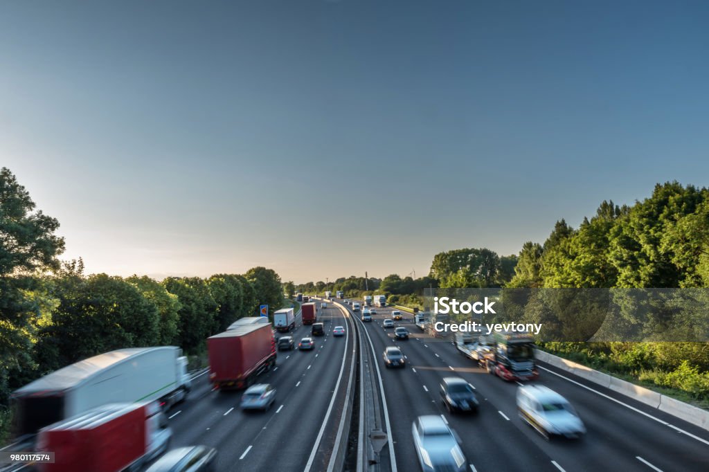 Sunset view heavy traffic moving at speed on UK motorway in England Sunset view heavy traffic moving at speed on UK motorway in England. Road Stock Photo