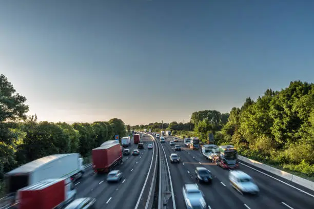 Sunset view heavy traffic moving at speed on UK motorway in England.