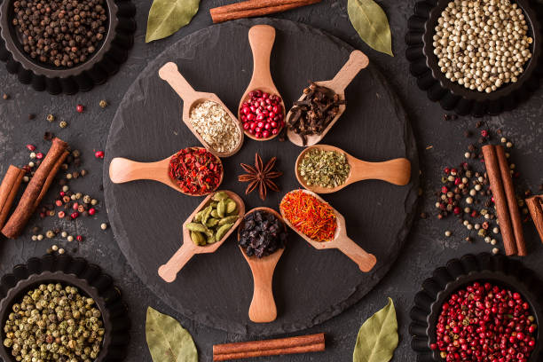 istock Various spices in wooden spoons on dark stone table. 980122170