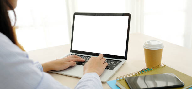 istock Woman hands using laptop computer with blank screen for mock up template background, business technology and lifestyle background concept 980126888
