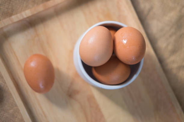 istock Close up of fresh eggs in white bowl. 980130524